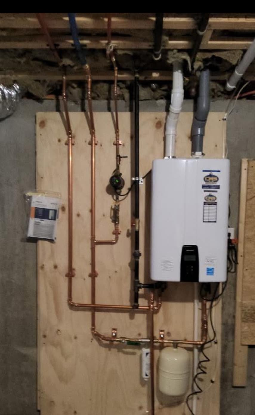 Recent Navien tankless water heater installation with clean copper manifold